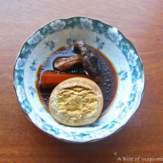Small bowl of Taiwanese-Style Soy Sauce Eggs with Carrots, egg cut in half to show the inside